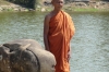 Monk posing for tourists on the "Naga" or symbolic rainbow bridge
